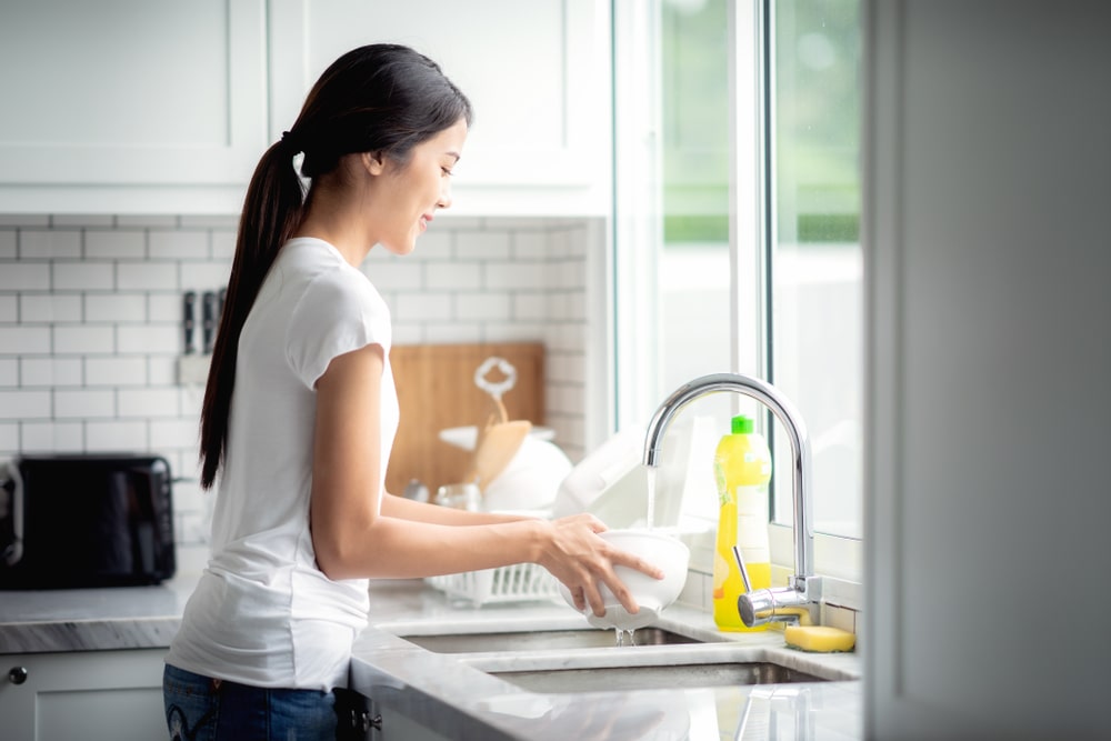 woman cleaning dishes with soft water