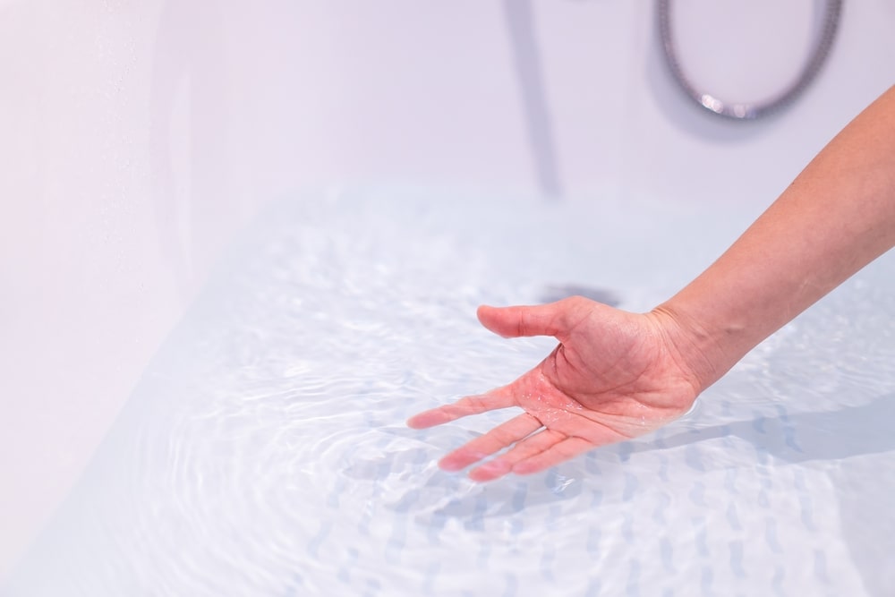 person putting hand in clean soft water