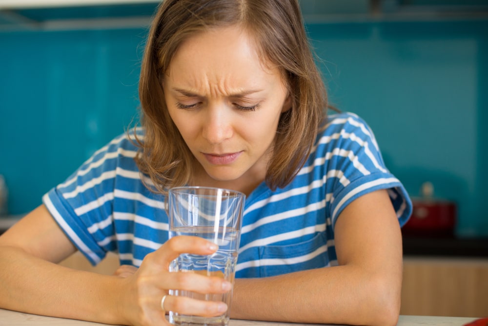 woman looking into water glass